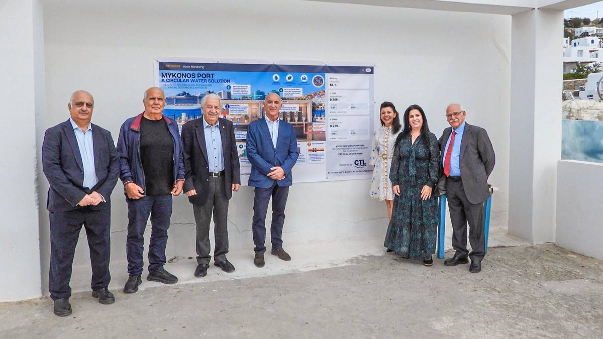 Στιγμιότυπο από την παρουσίαση του συστήματος επαναχρησιμοποίησης νερού στο λιμάνι της Μυκόνου, μπροστά στην ενημερωτική πινακίδα του έργου.