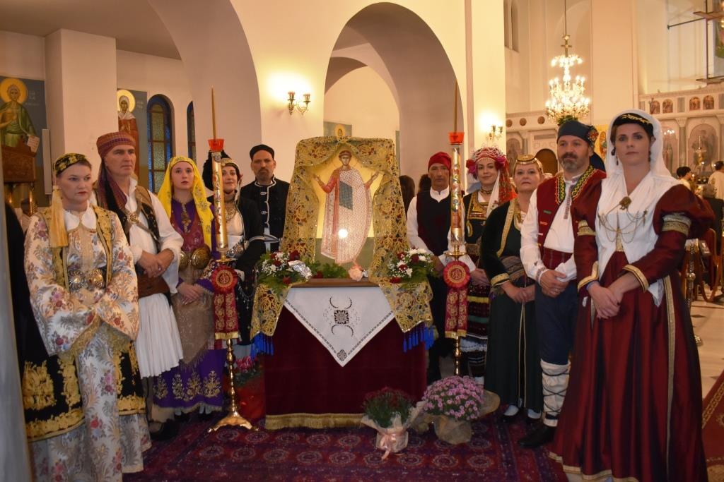 Μέλη του Συλλόγου «Χοροδρώμενο» με παραδοσιακές στολές δίπλα στην εικόνα του Αγίου Δημητρίου